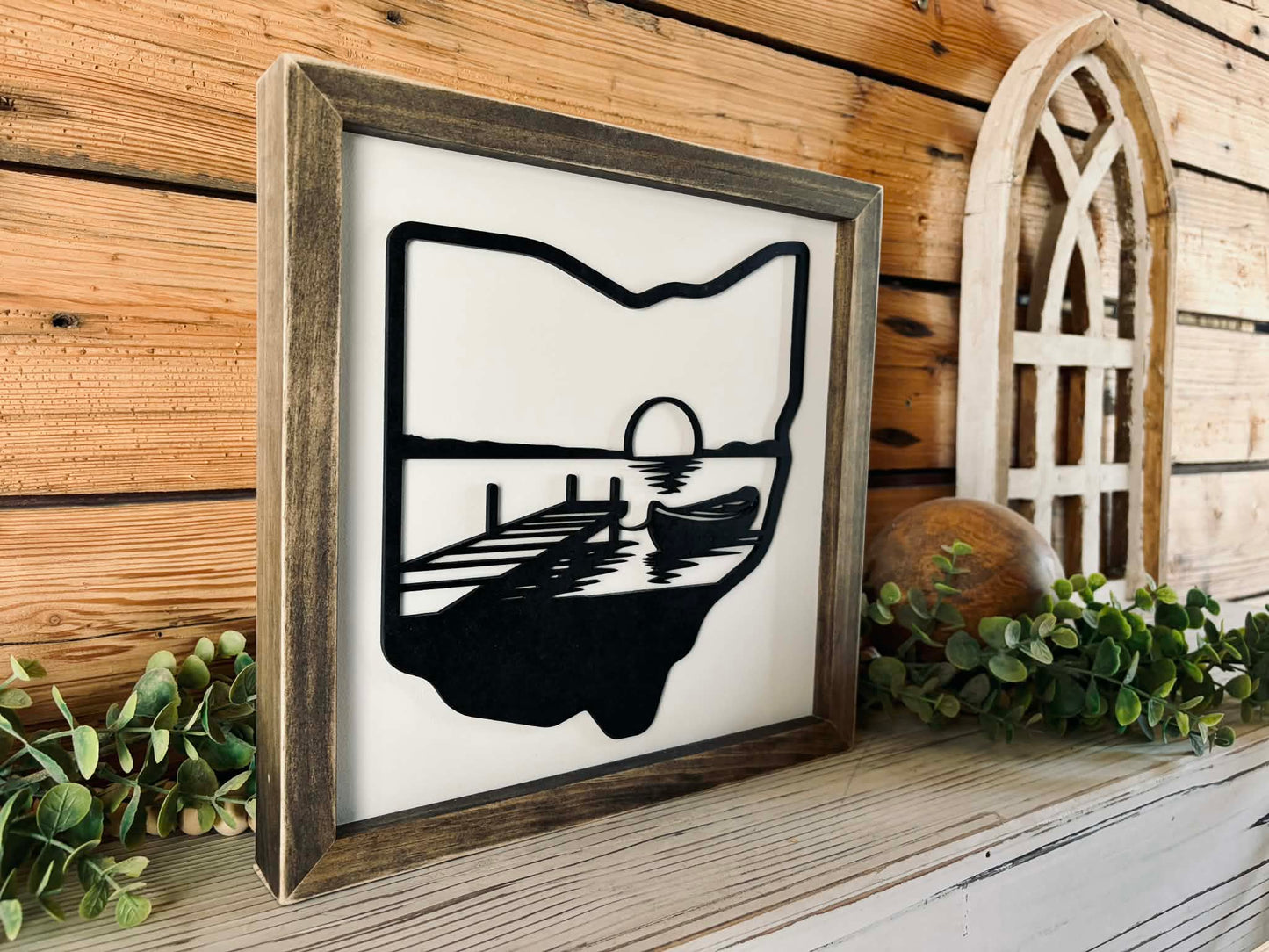 Modern farmhouse Ohio state wall art with a black state silhouette and white layered lake scene in a stained pine frame.