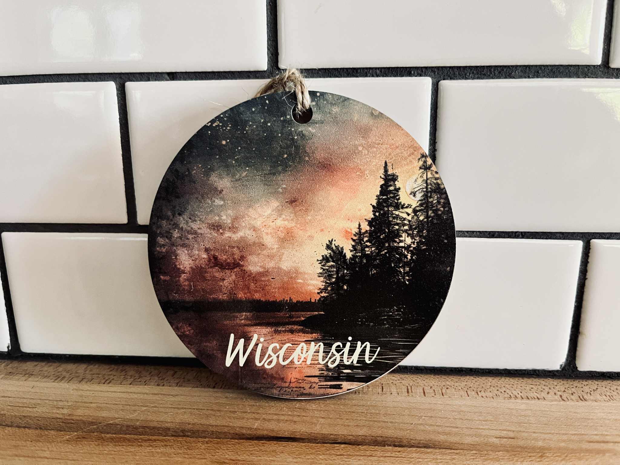 Wisconsin sunset wood ornament with forest silhouette and jute cord